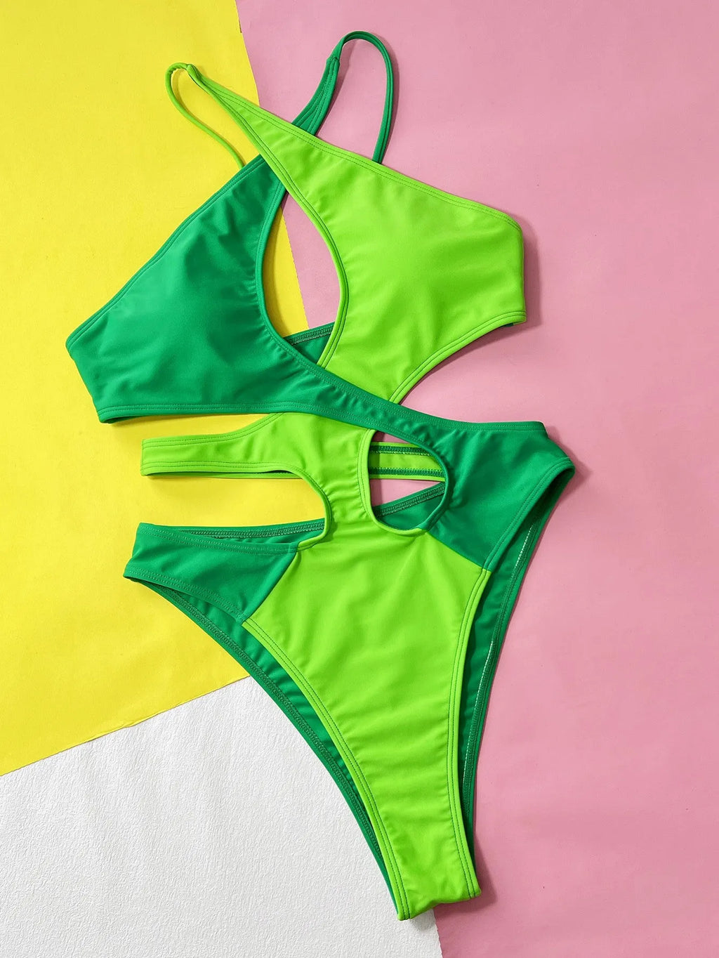 Green solid colour women's one-piece nylon swimsuit on a hanger.