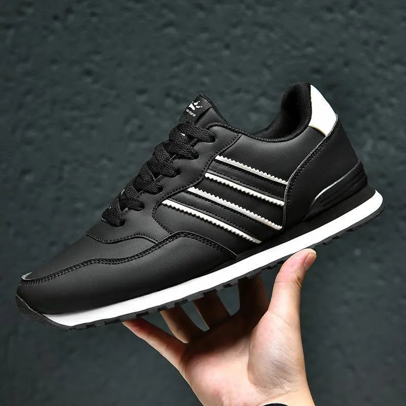 Men's black casual running shoes with carved wing pattern and a high heel.