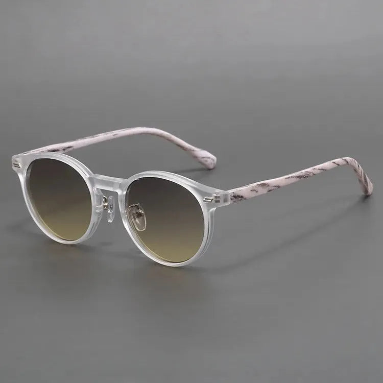 Retro round frosted sunglasses in leopard print and sand colours on a patterned background.