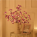 A 65cm long pink LED phalaenopsis branch decorative light on a dark background.