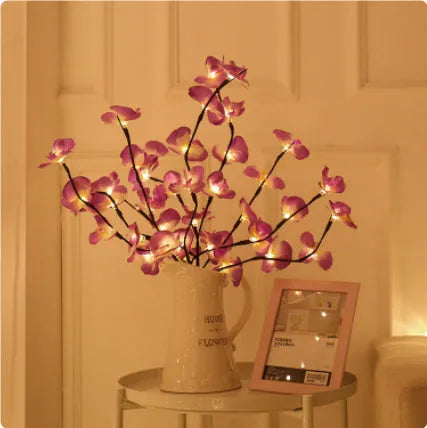 A 65cm long pink LED phalaenopsis branch decorative light on a dark background.