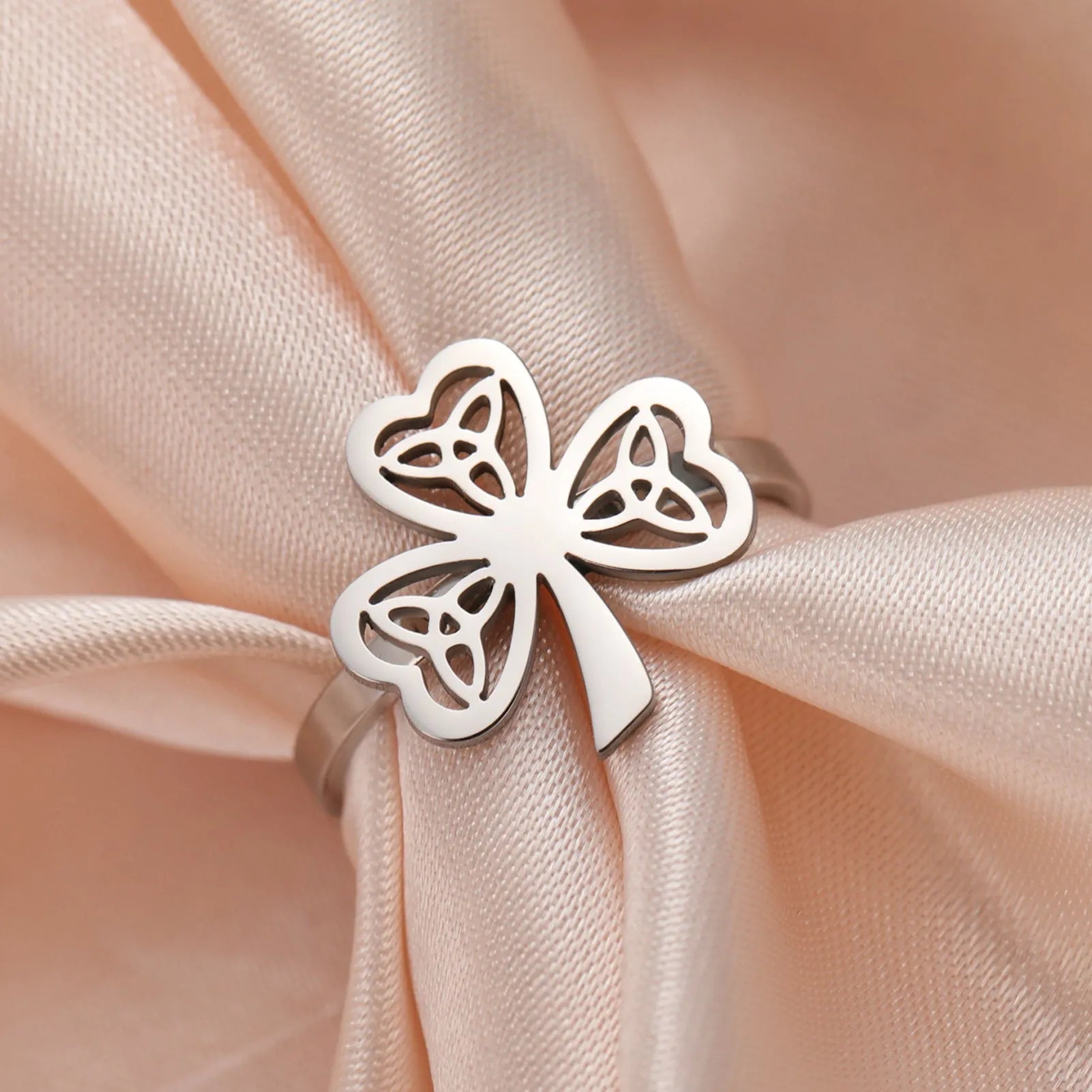 Women's hollow stainless steel fashion ring in gold or steel colour on a size chart.