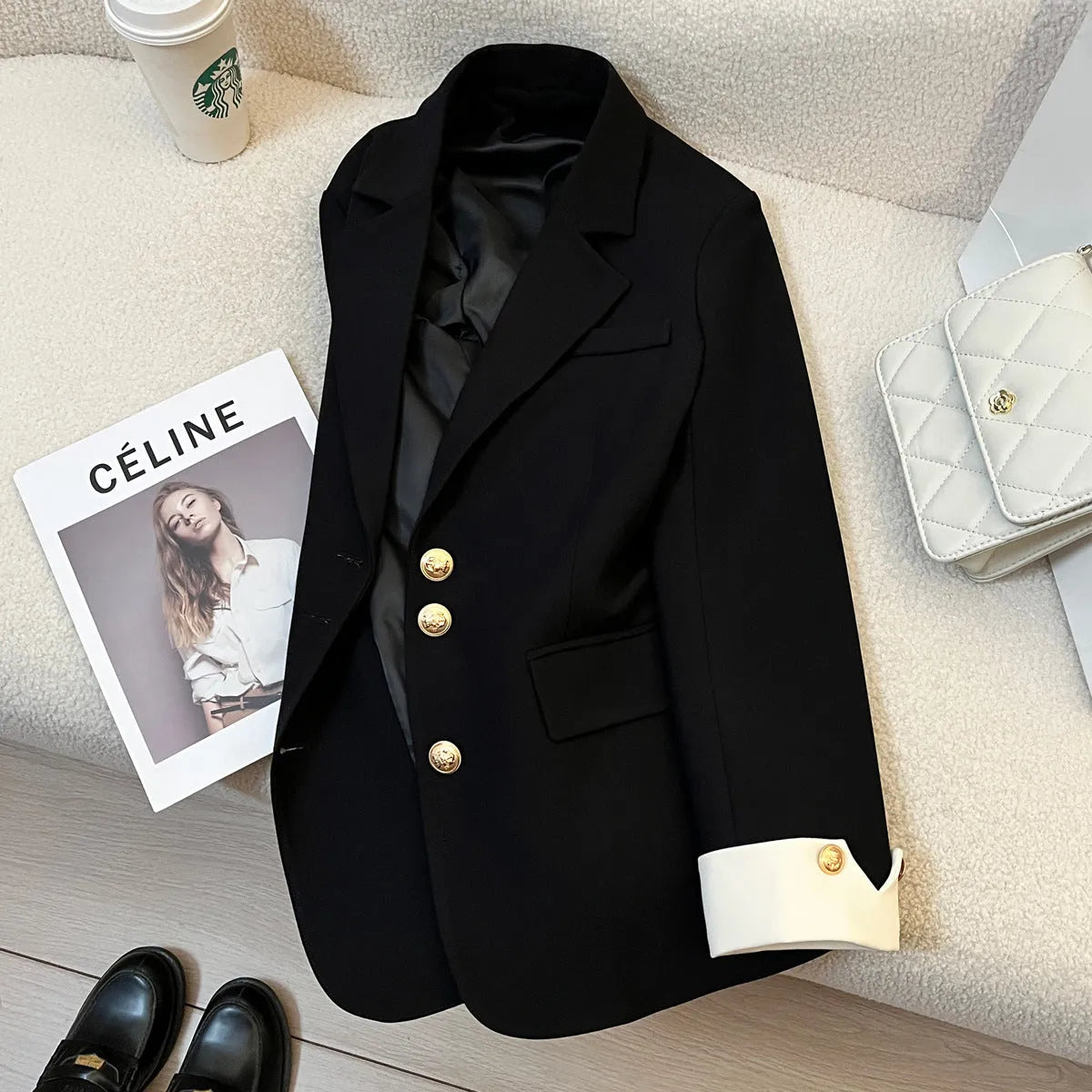 Milky white loose-fit mid-length women's coat with long sleeves and pockets on a hanger.