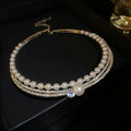 Close-up of a silver curved geometric alloy necklace resting on a collarbone.