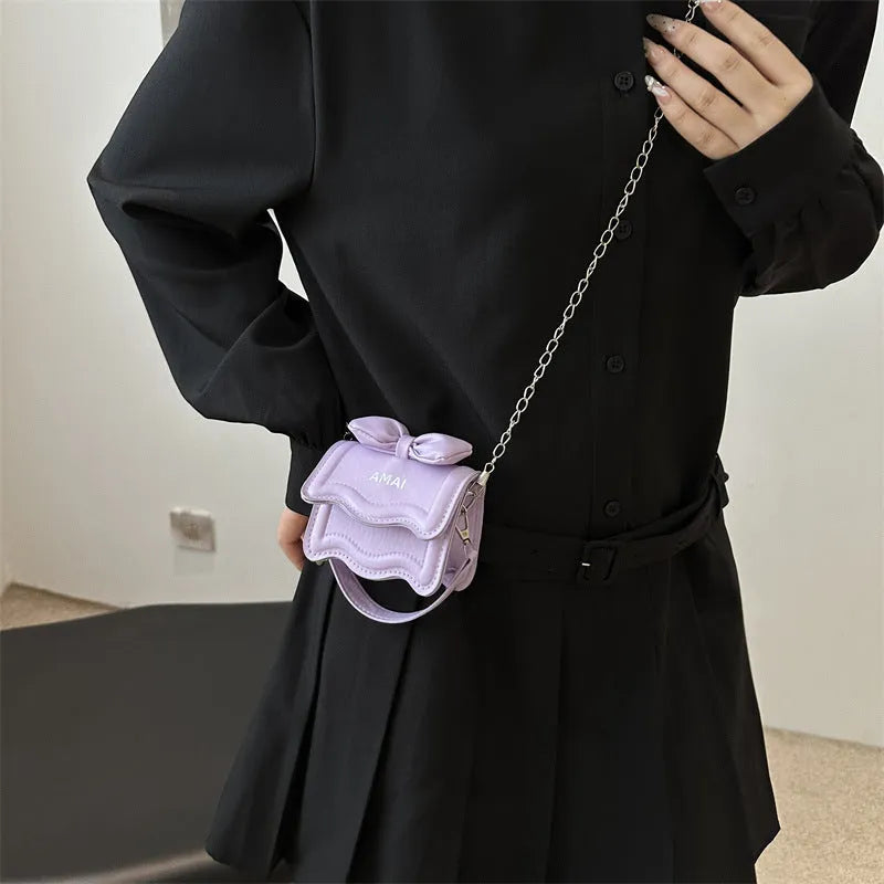 Small black PU leather crossbody bag for women with an adjustable shoulder strap.