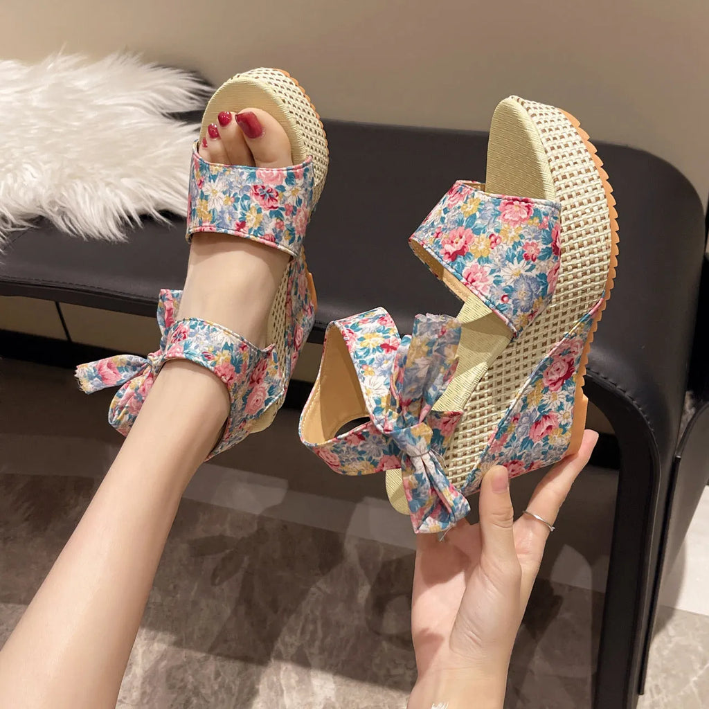 Women's floral patterned peep toe wedge sandals with an ankle strap buckle.