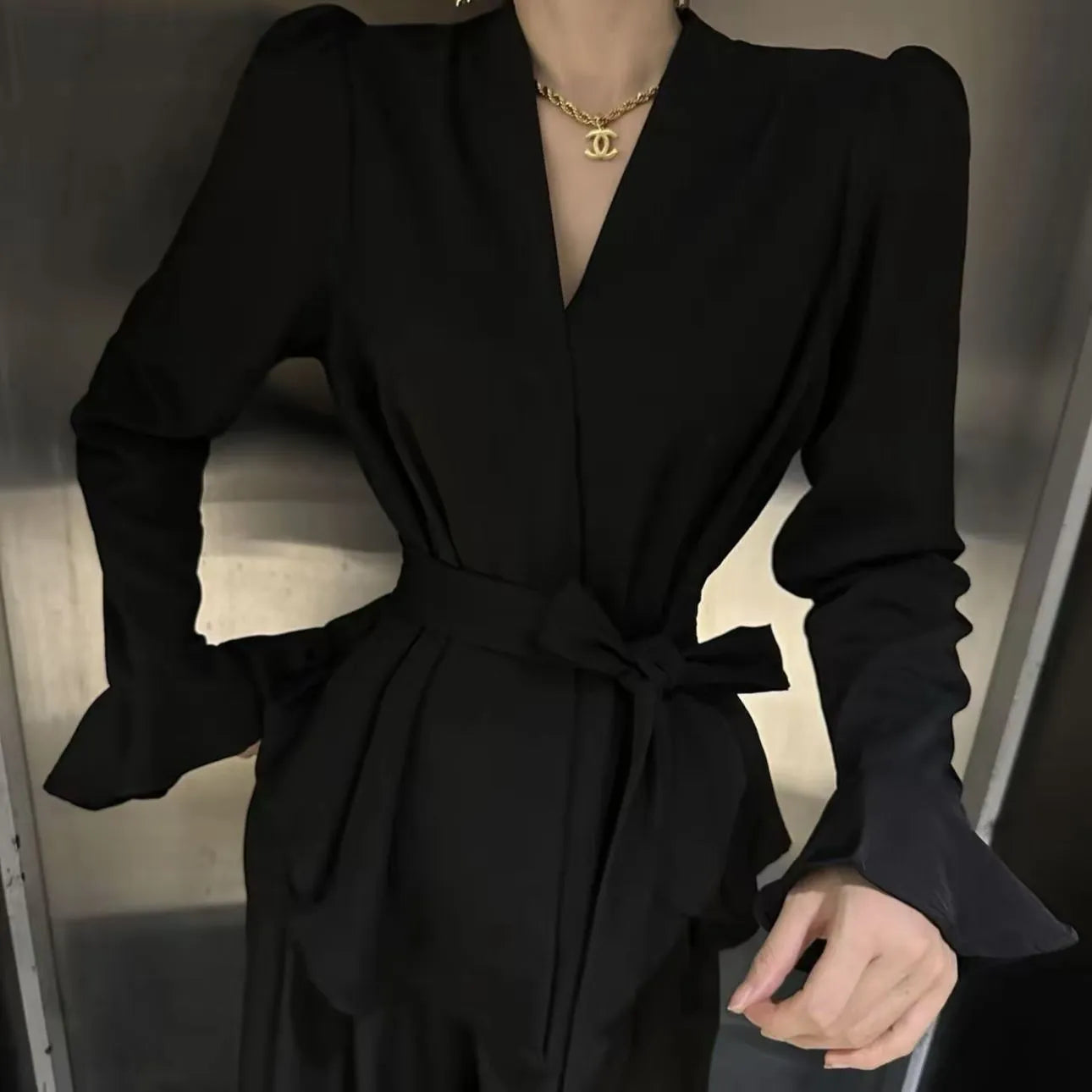 Women's black French-style shirt with irregular collar, long bell sleeves, and a tied front.