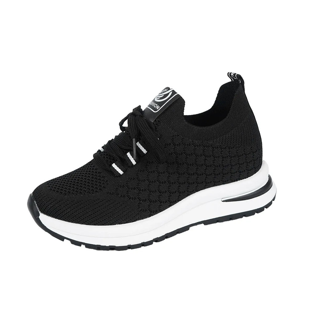 Black and white women's flat lace-up mesh sneakers with round toe on a rubber sole.