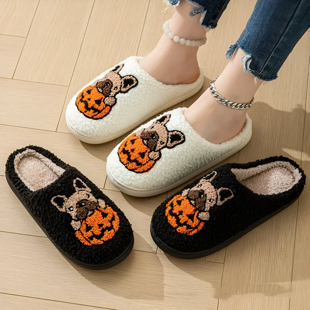 Black and white Halloween slippers with pumpkin pattern, plush lining, and textured non-slip rubber soles.