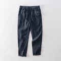 Men's linen straight leg trousers in light grey showing mid-waist design and straight cut