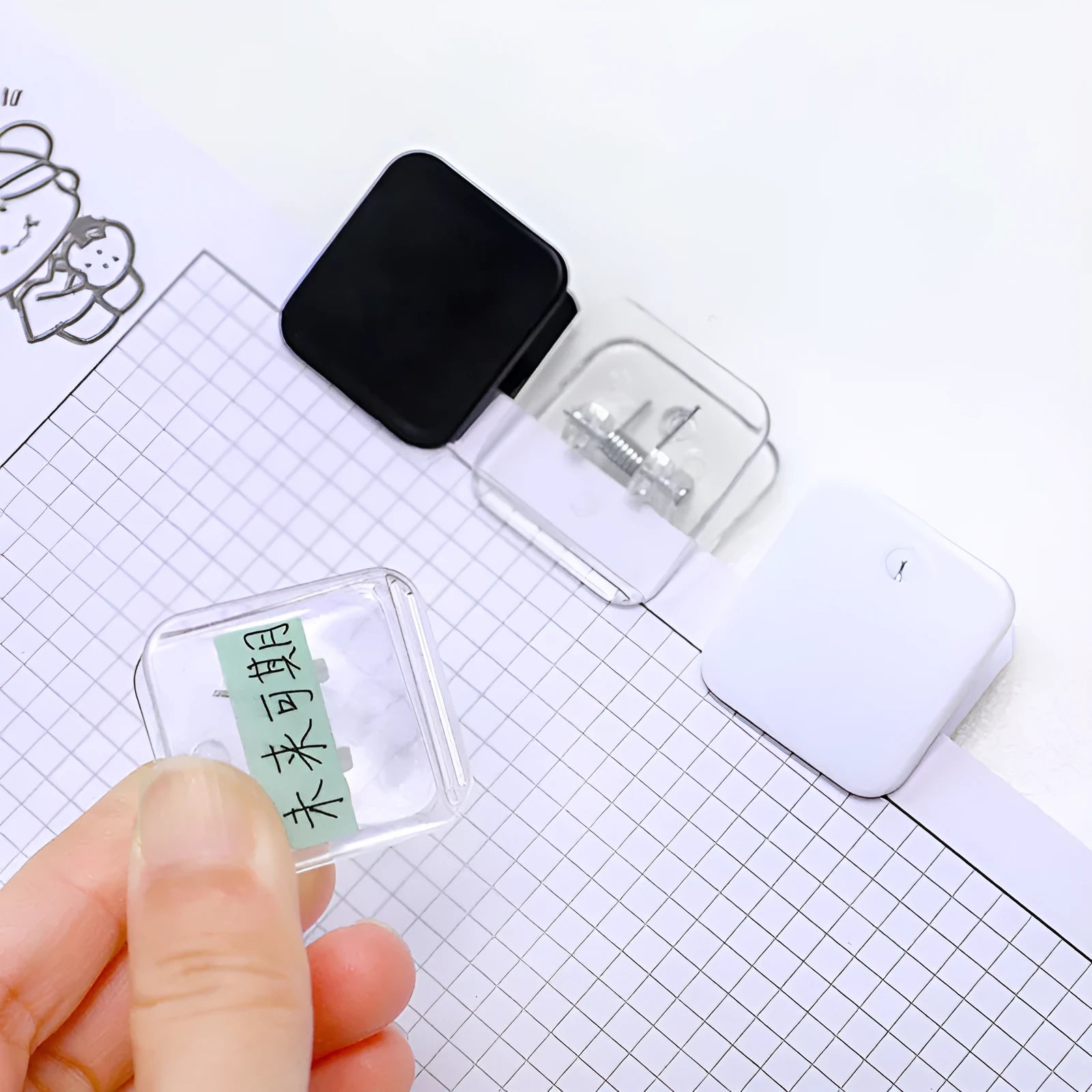 Small square plastic photo note holder in white, black and transparent colours on a desk