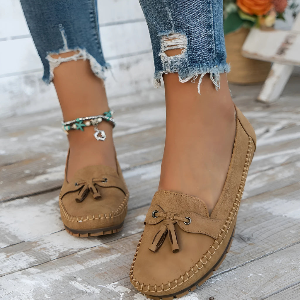 Women's solid colour suede flat shoes with a bow, shown in pink, apricot, grey, and blue on a casual background.