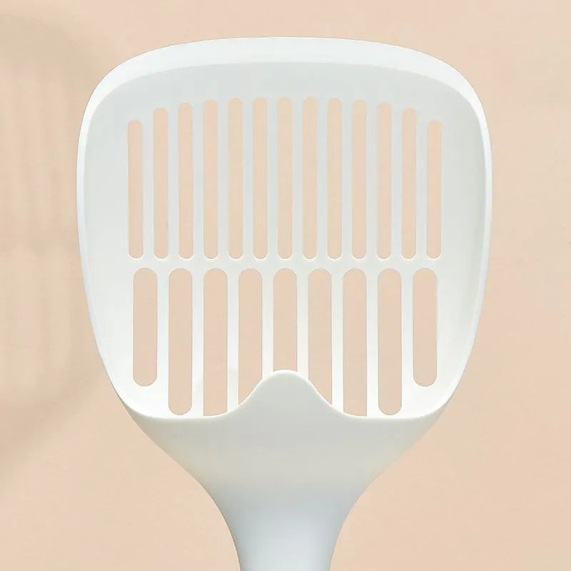 White plastic cat litter scoop with an integrated storage base on a flat surface.