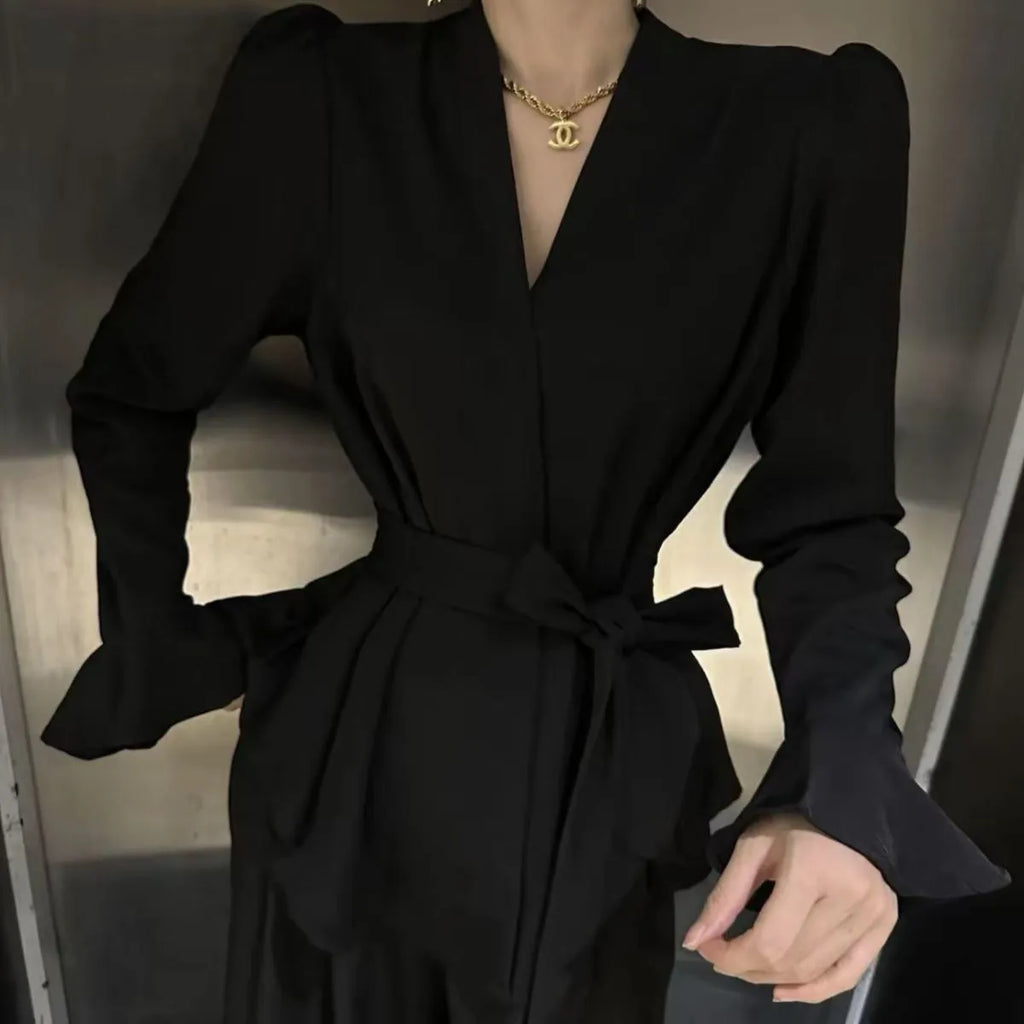 Women's black French-style shirt with irregular collar, long bell sleeves, and a tied front.