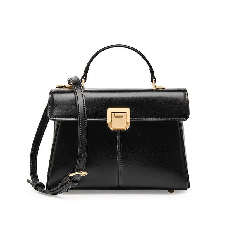 Black leather women's shoulder bag with vachette clasp, shown open to reveal internal zippered pocket.