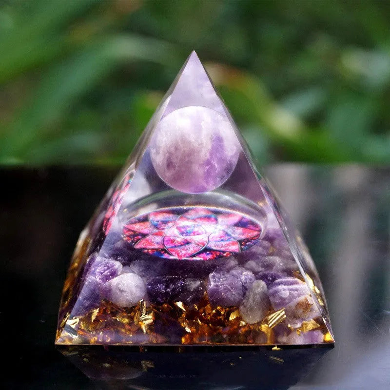 Small 6cm high clear epoxy resin pyramid ornament filled with colourful natural crystal gravel on a shelf.
