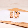 Rose gold hollowed-out stainless steel earrings showing three heart shapes in a circular design.