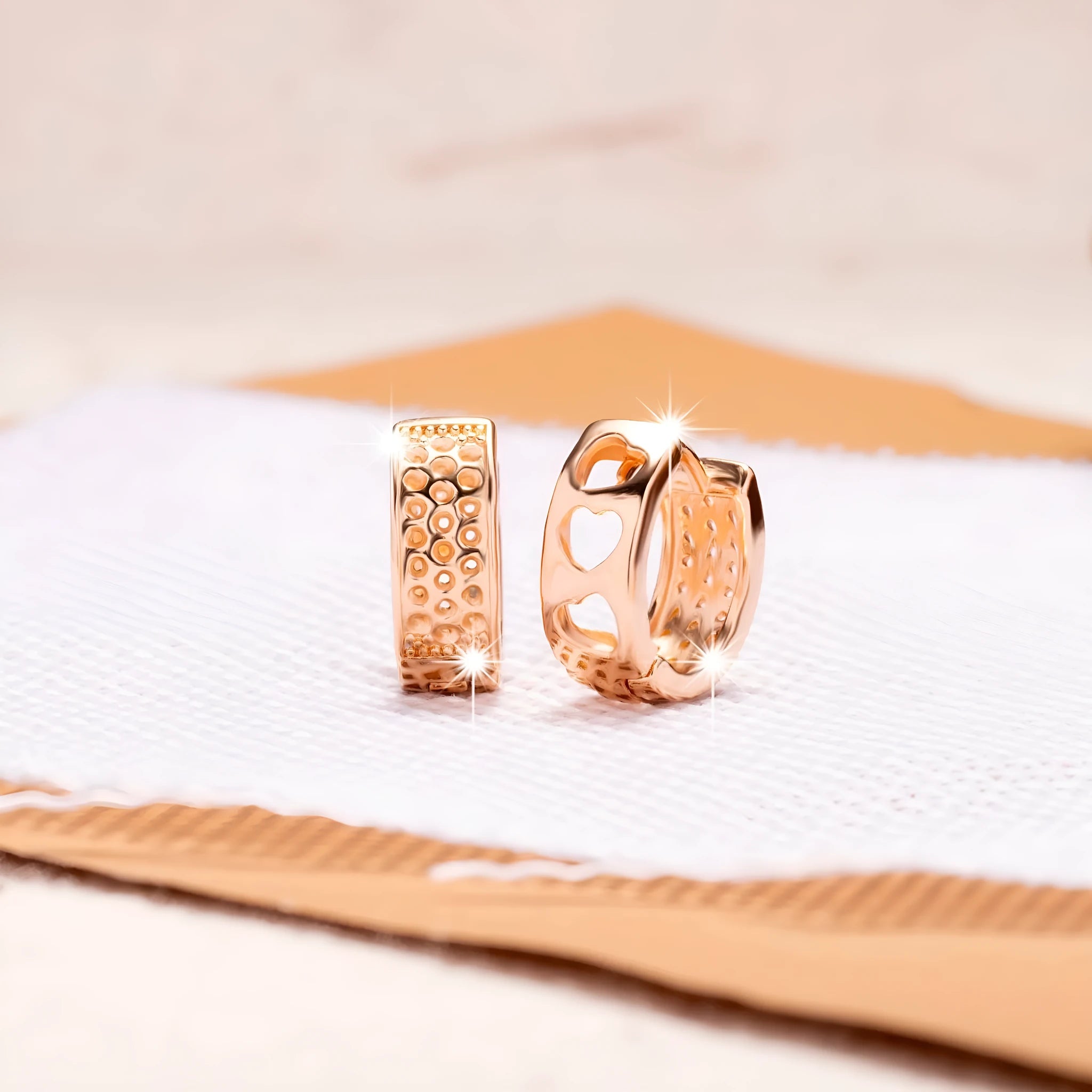 Rose gold hollowed-out stainless steel earrings showing three heart shapes in a circular design.