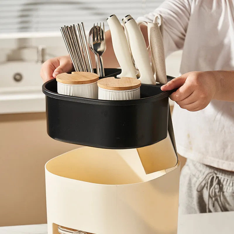 White rotating kitchen storage bucket and four-compartment spice box organiser for cutlery and seasonings.