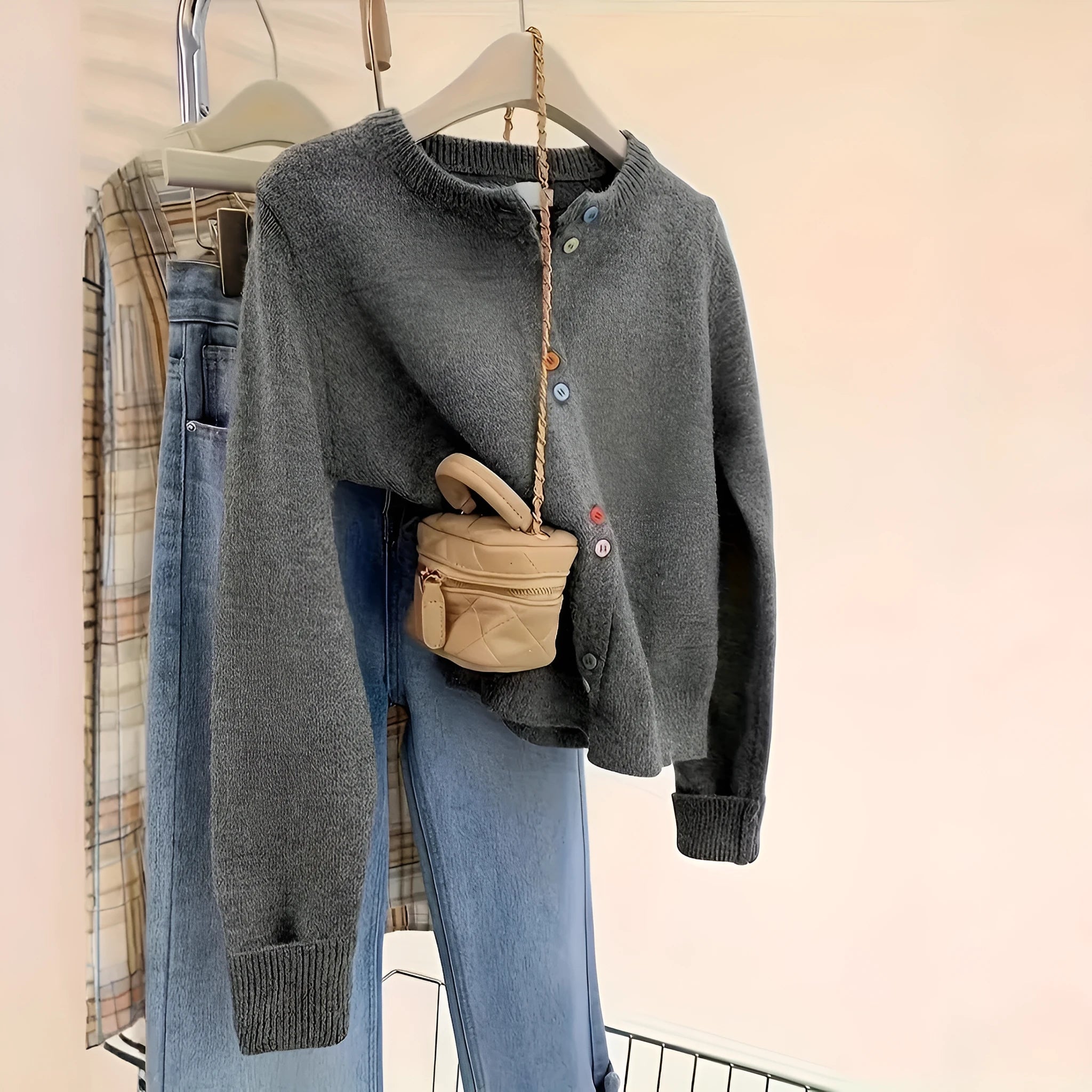 Dark grey women's button-front cardigan with long sleeves on a hanger.