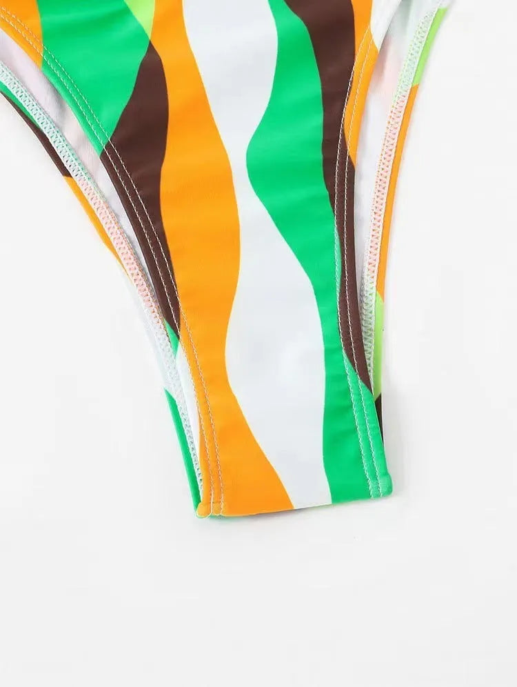 Women's yellow green printed three-piece bikini set with matching beach skirt laid flat.