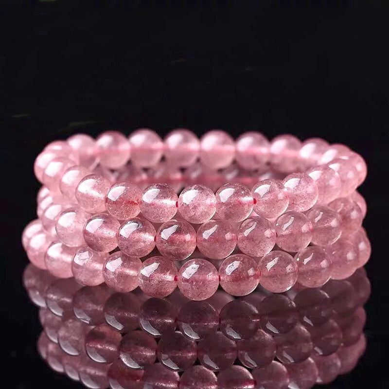 A bracelet made of round, polished pink strawberry quartz beads in three size options.