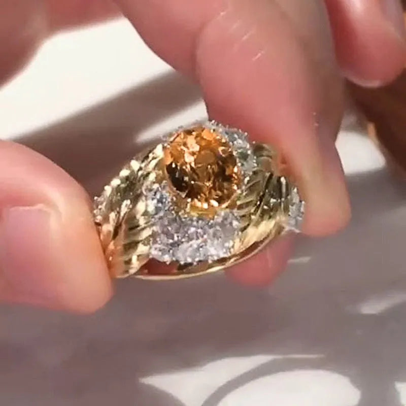 Gold-coloured copper ring with an embossed geometric feather pattern and inlaid yellow zircon stones.