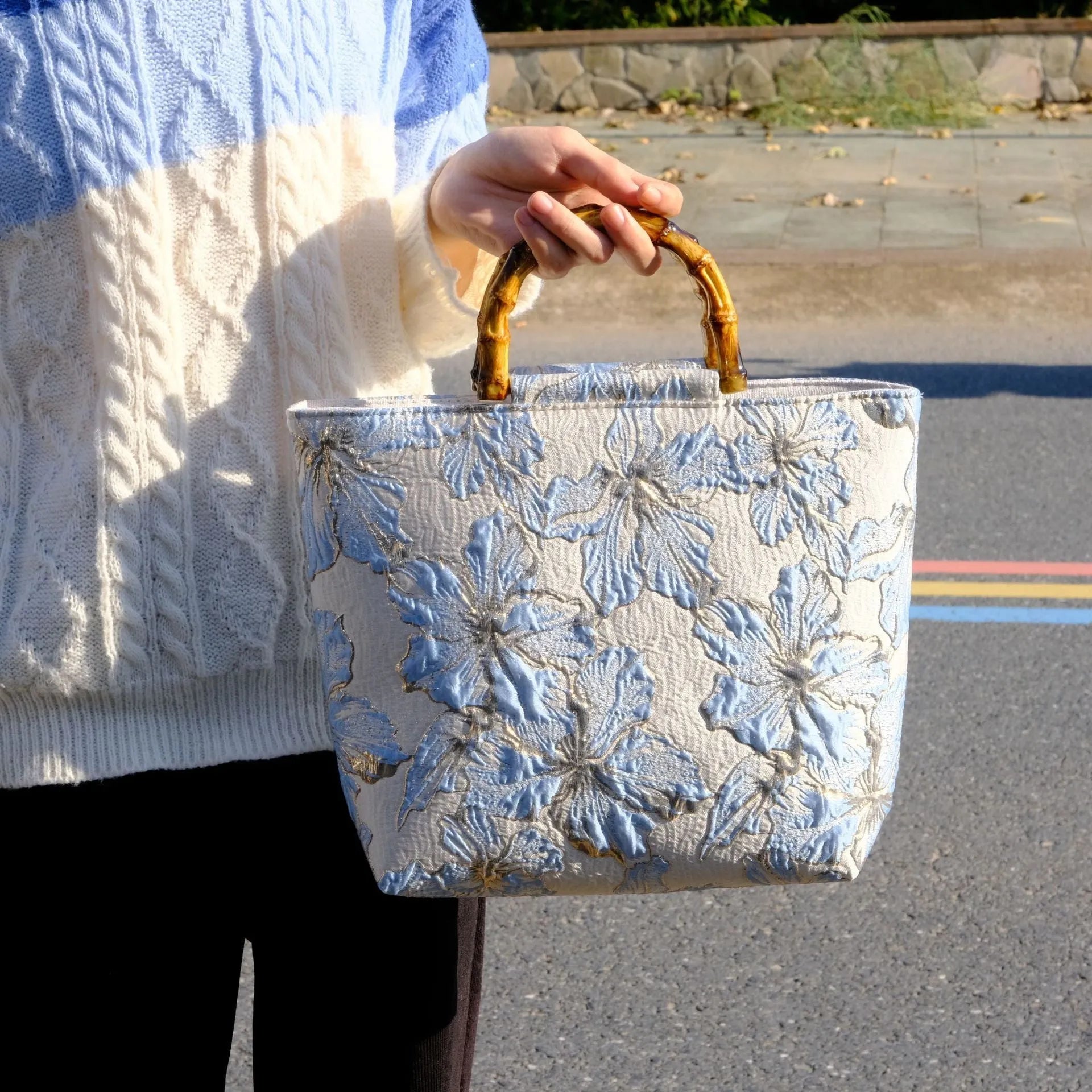 Light blue canvas shoulder bag with bronzing flower print, square shape, and two adjustable connector straps