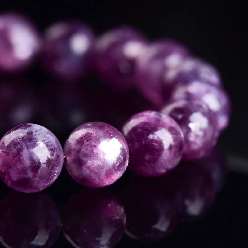 Polished purple crystal bracelet with geometric beads on a white background.