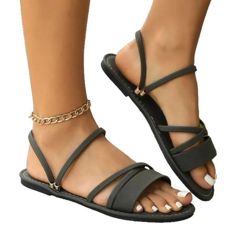 Women's black plus size sandals with a round toe, flip-toe buckle, and a cross strap over the foot.