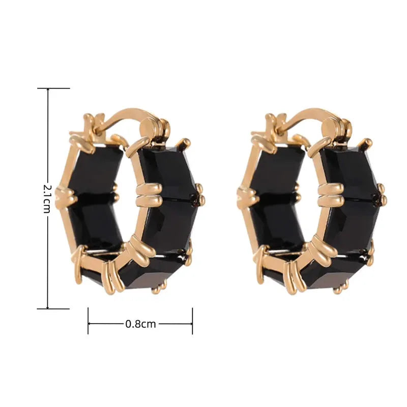 Geometric gold U-shaped hoop earrings with a round black zircon stone, shown from a side view.