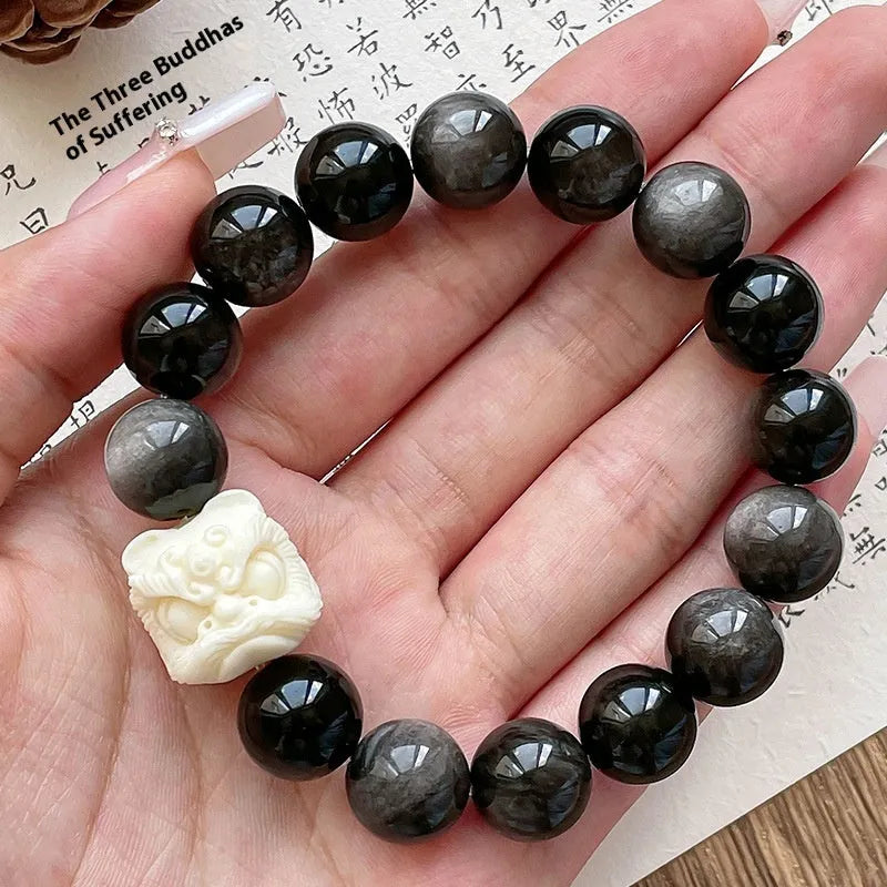 Handcrafted Xingshi obsidian prayer bead bracelet with chamfered square grain design, shown in 12mm size.