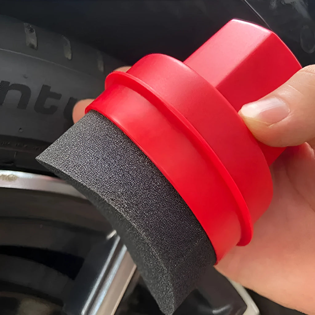 Black and red car tyre polishing sponge brushes with lids on a workbench.