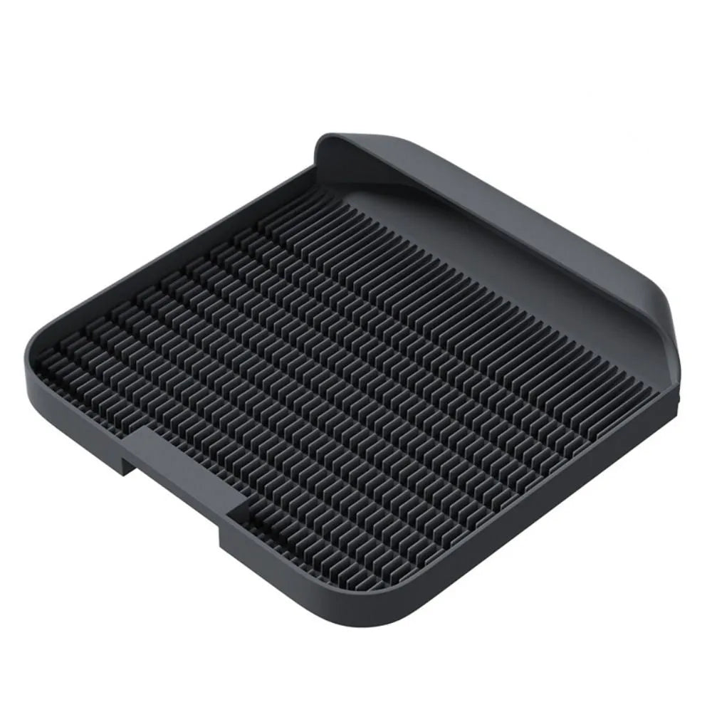 Large black cat litter pedal with slanted mouth and textured grooves beside a litter tray