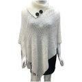 Dot-patterned acrylic knitted shawl cloak in apricot colour, laid flat.