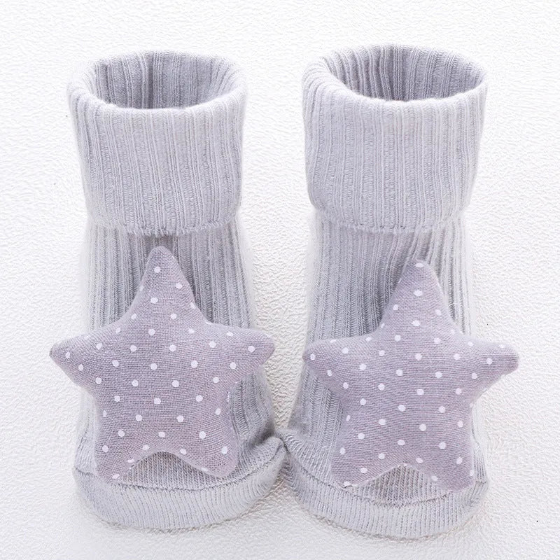 Cotton baby floor socks in a pink bow pattern, shown on an infant's feet.