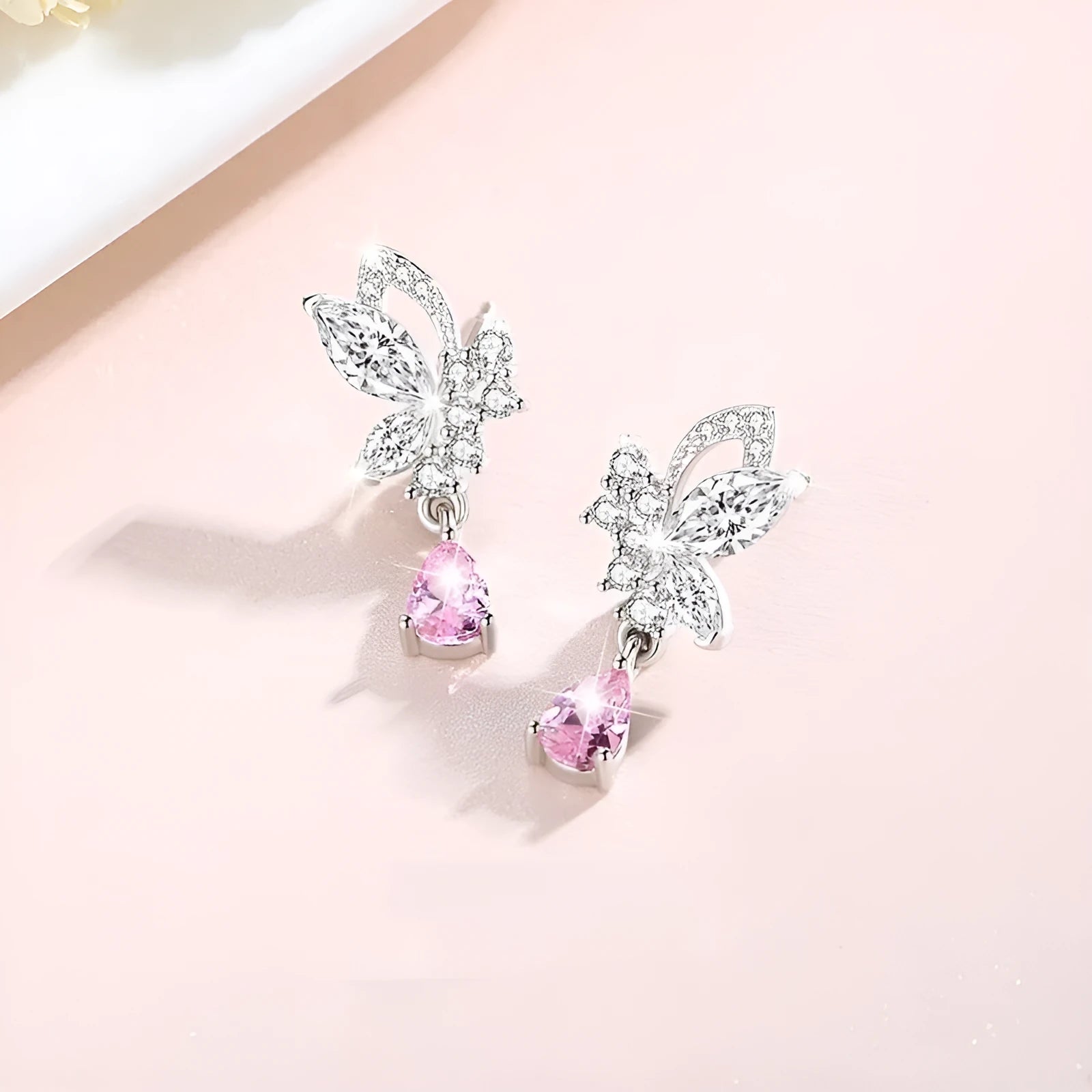A pair of silver butterfly stud earrings with clear crystals on a white background.