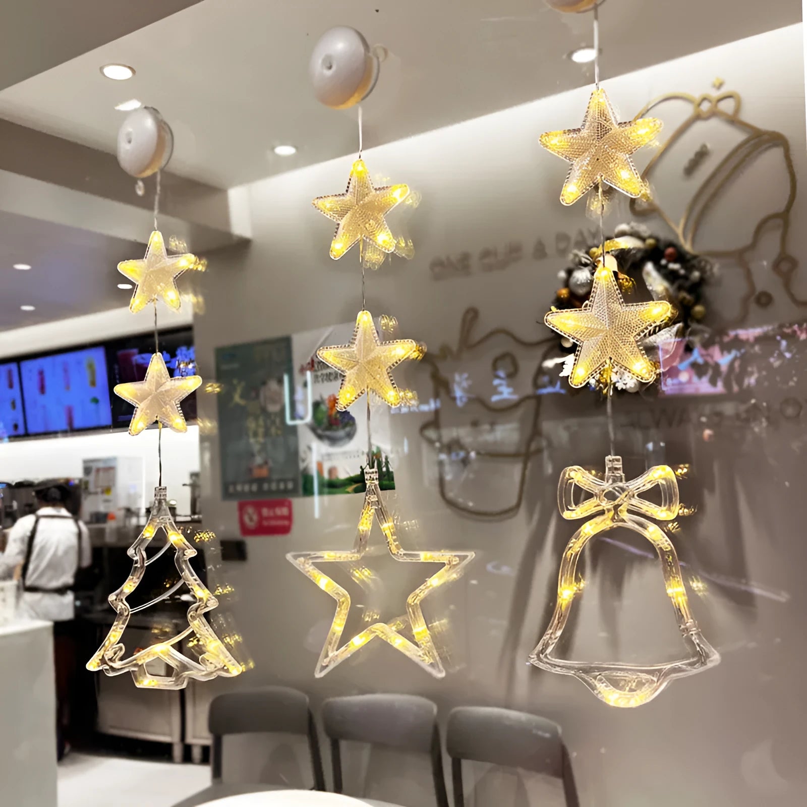 Three Christmas LED light ornaments with suction cups hanging on window