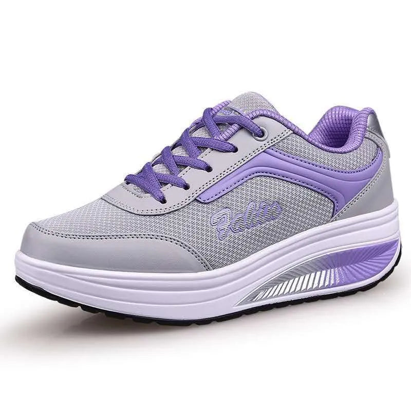 Women's grey and black casual sports shoes with a medium heel on a plain background