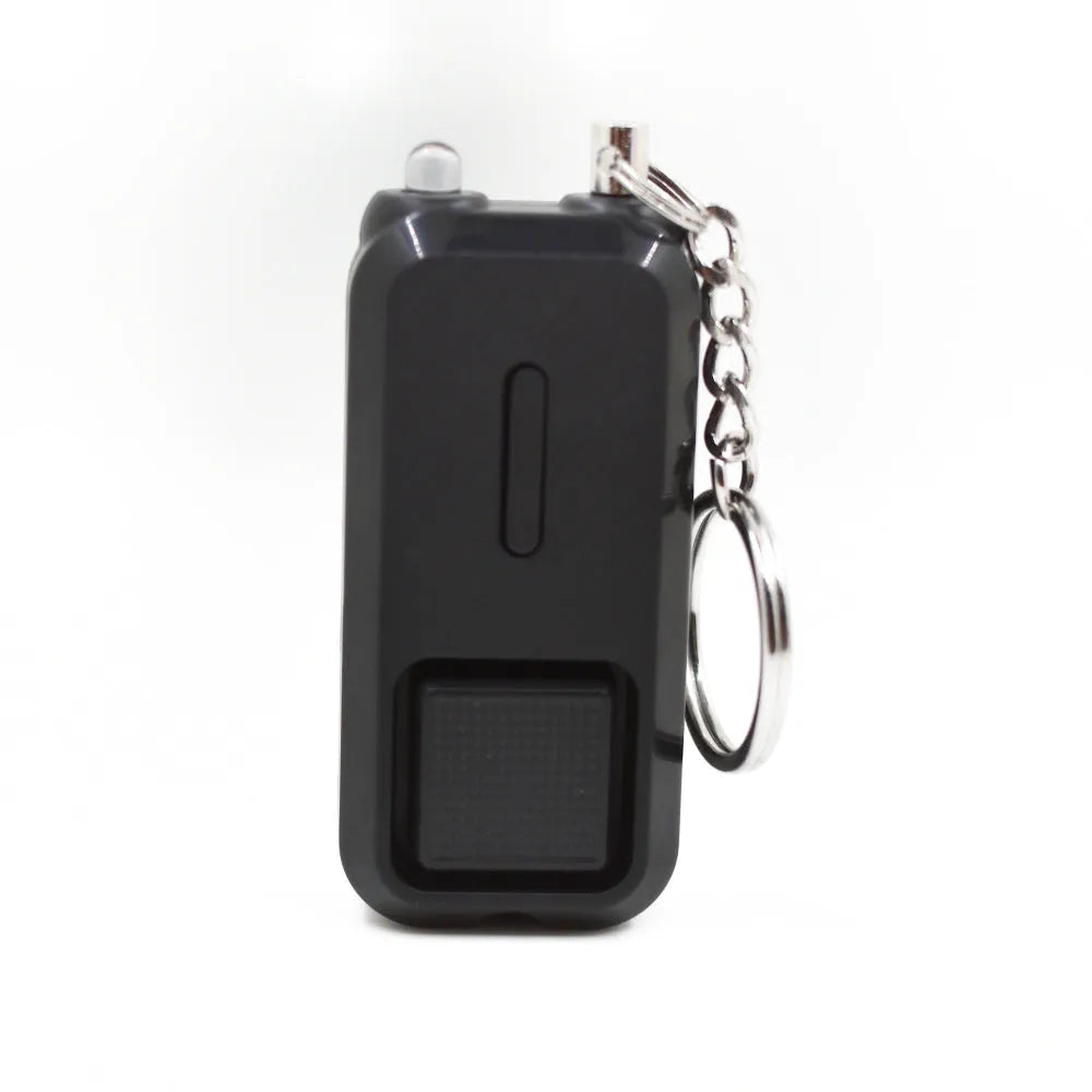 Small pink personal safety alarm on a keyring with a pull-pin activation mechanism.