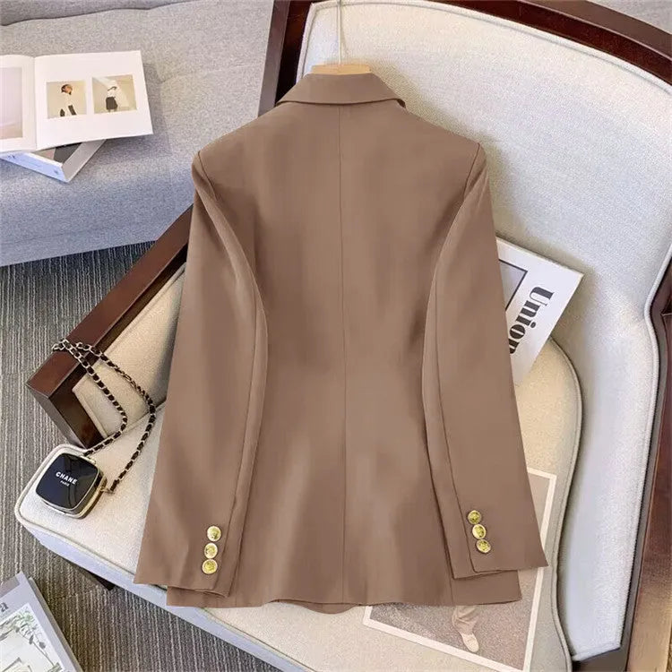 Women's loose fit polyester blouse and matching trousers in beige, shown on a hanger.