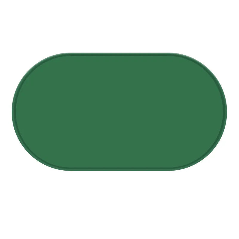 Green silicone waterproof placemat for cat food and water bowls on a floor.