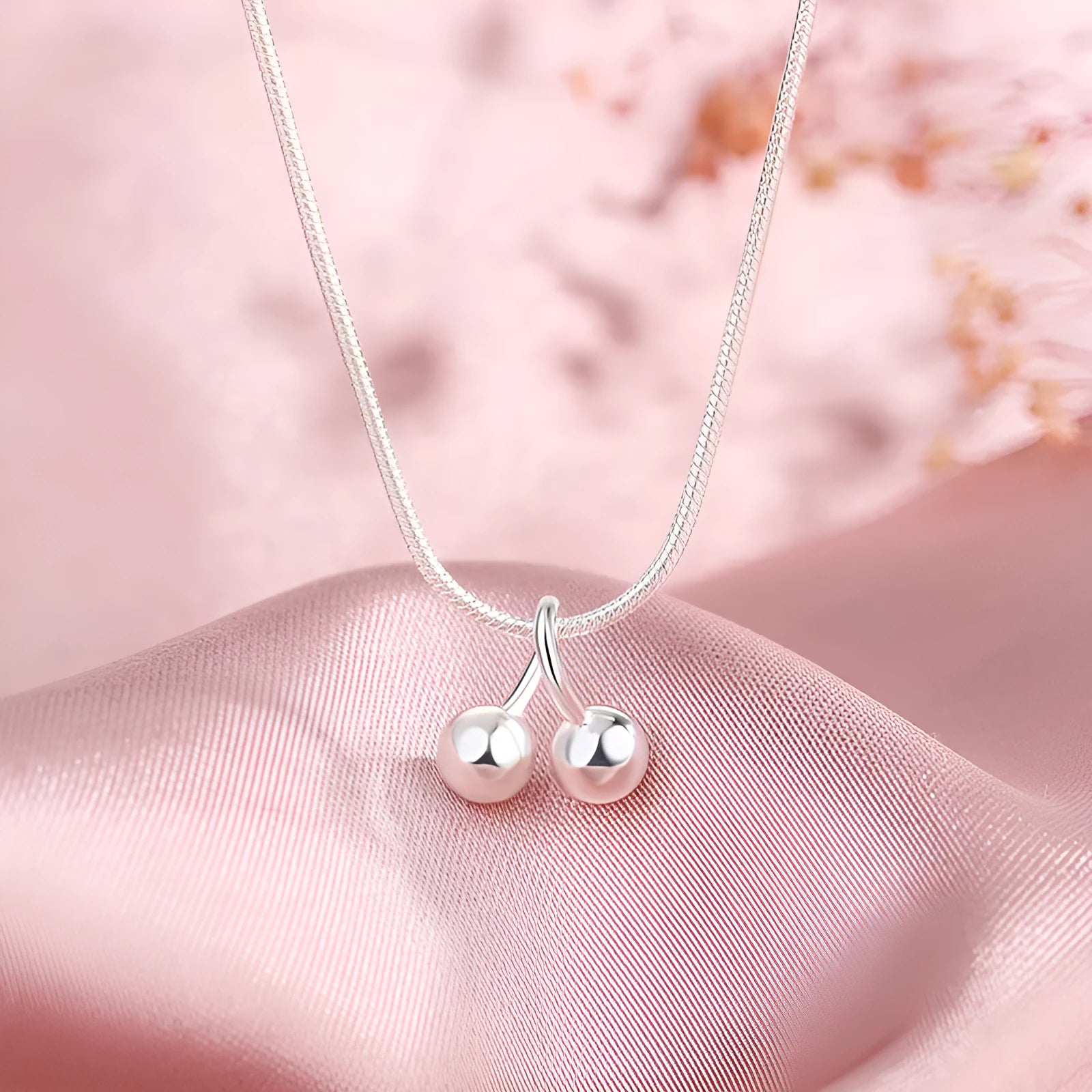 925 silver cherry pendant necklace with an adjustable snake bones chain on a white background.