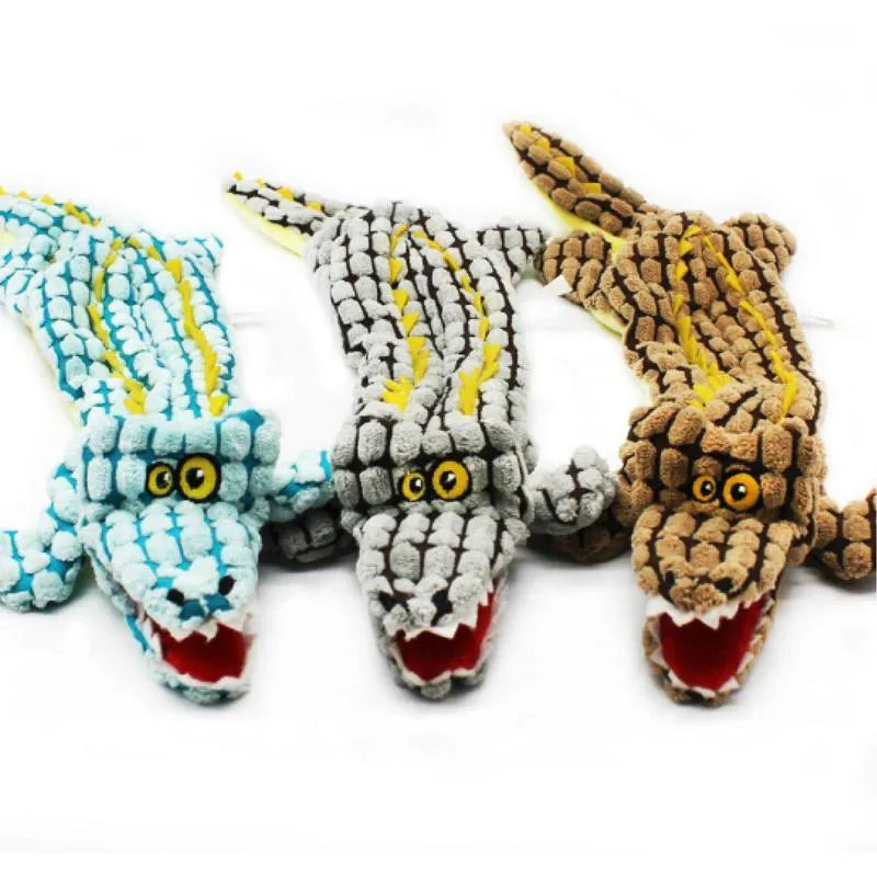 Blue plush crocodile-shaped dog toy with corduroy texture and squeaker, shown next to measuring tape