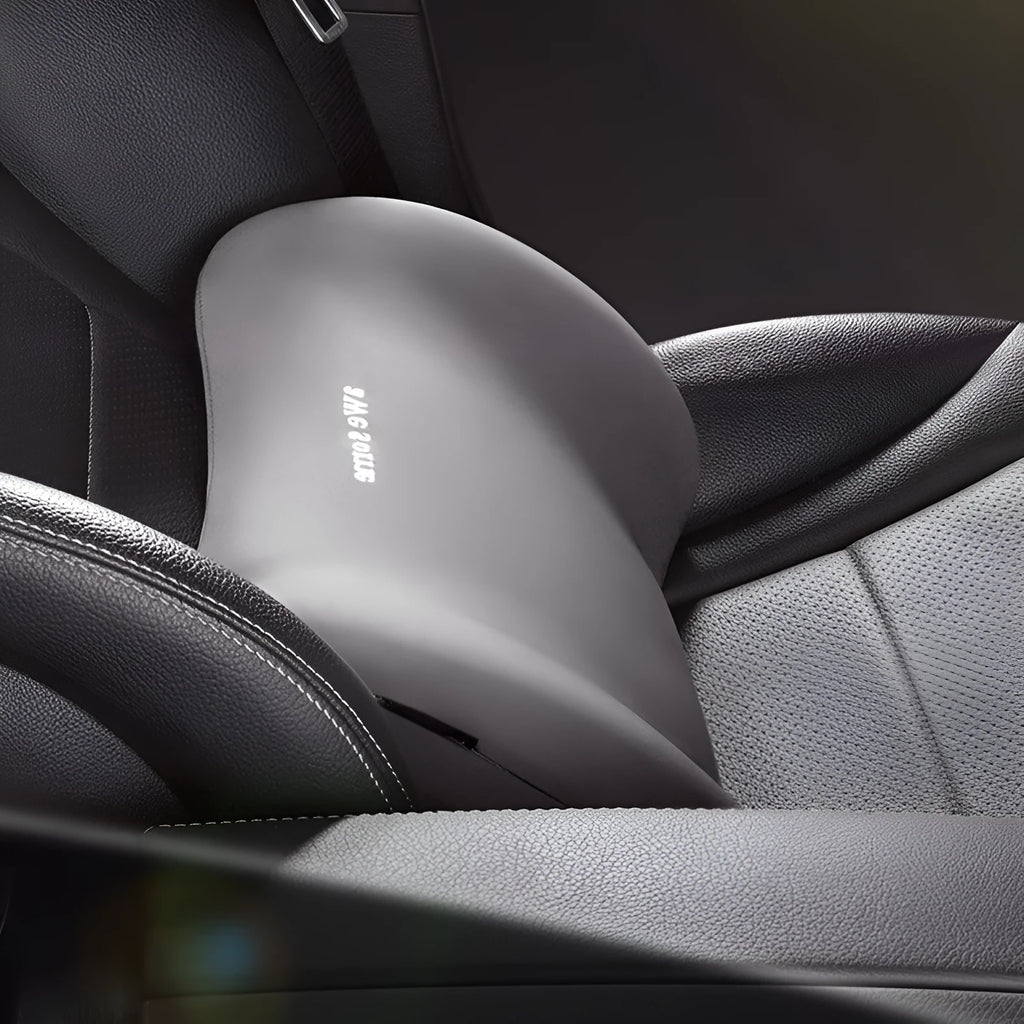 Cow head style black automotive headrest pillow and matching lumbar support pillow on a car seat.