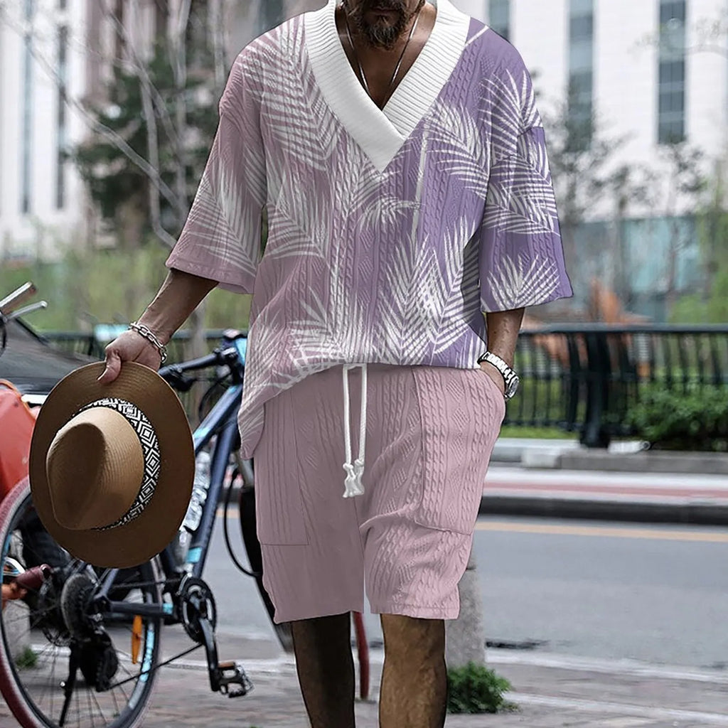Man wearing a light blue printed drop-shoulder knitted top with matching shorts from a casual summer suit.