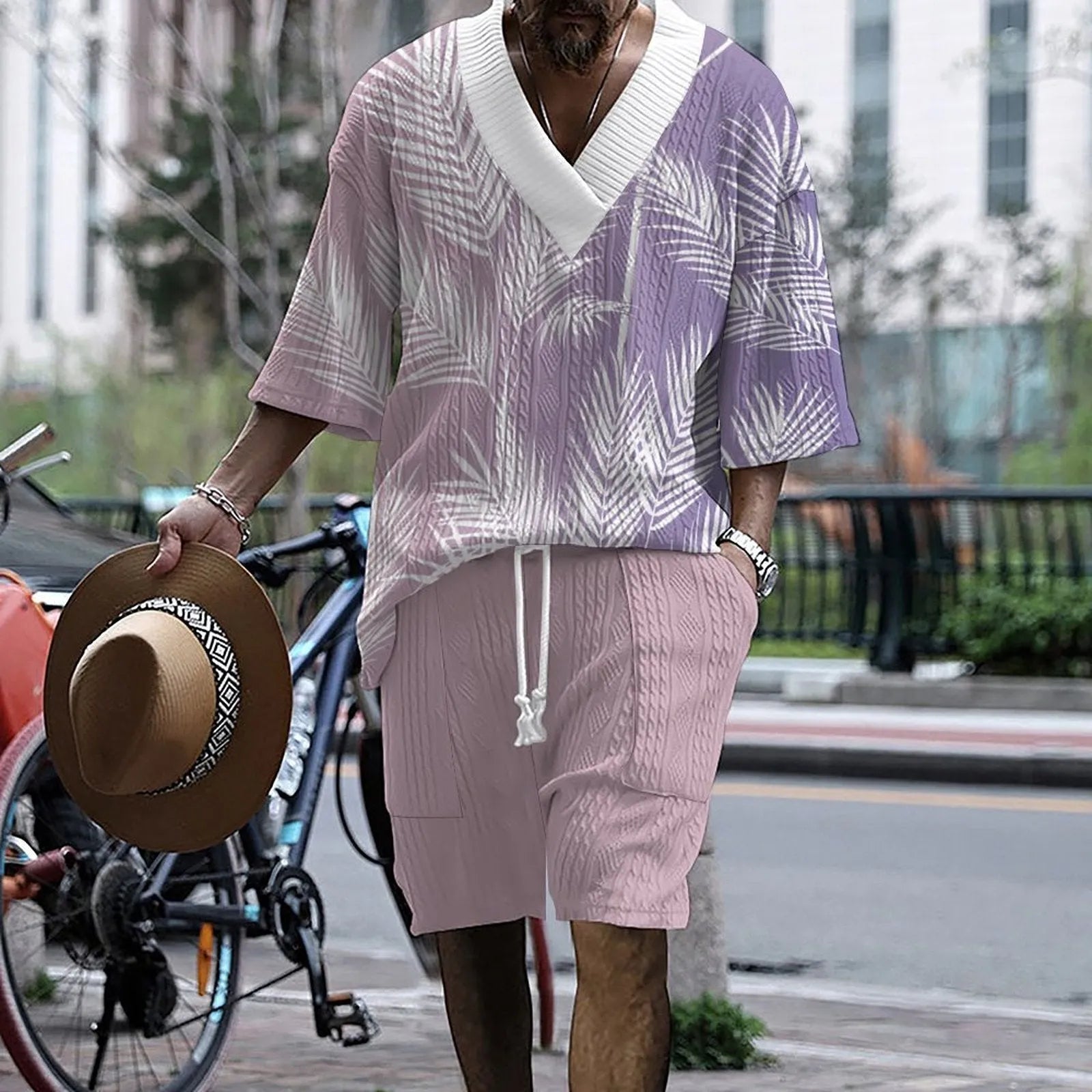 Man wearing a light blue printed drop-shoulder knitted top with matching shorts from a casual summer suit.