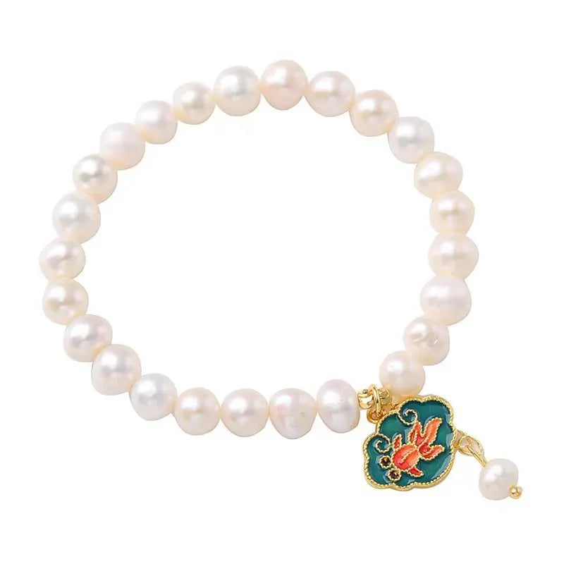 White antique freshwater pearl bracelet with a vintage goldfish and baroque lotus pendant on a chain.