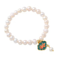 White antique freshwater pearl bracelet with a vintage goldfish and baroque lotus pendant on a chain.