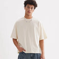 A man's loose fit pure cotton T-shirt in apricot colour on a hanger.